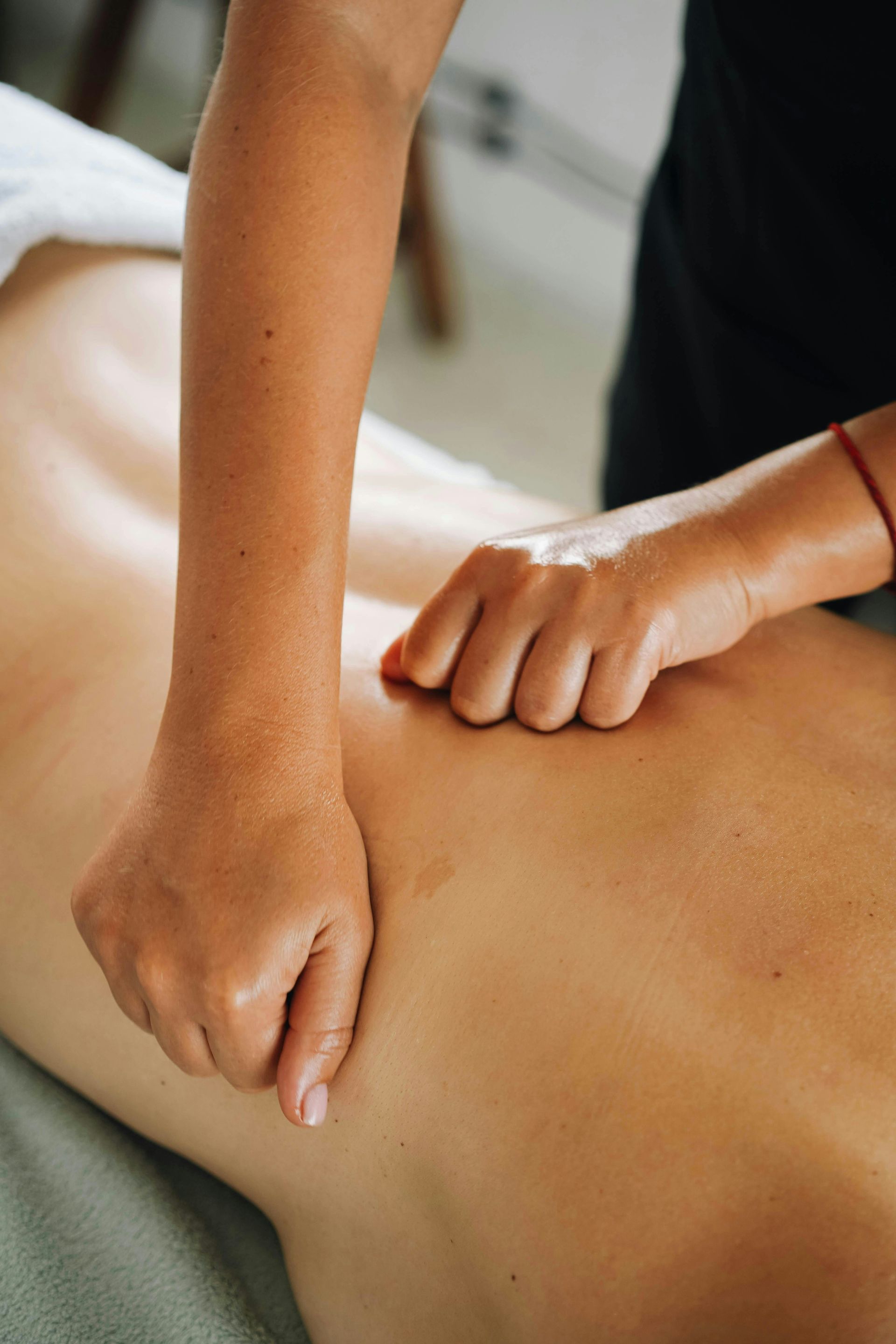 A massage therapist provides a back massage.