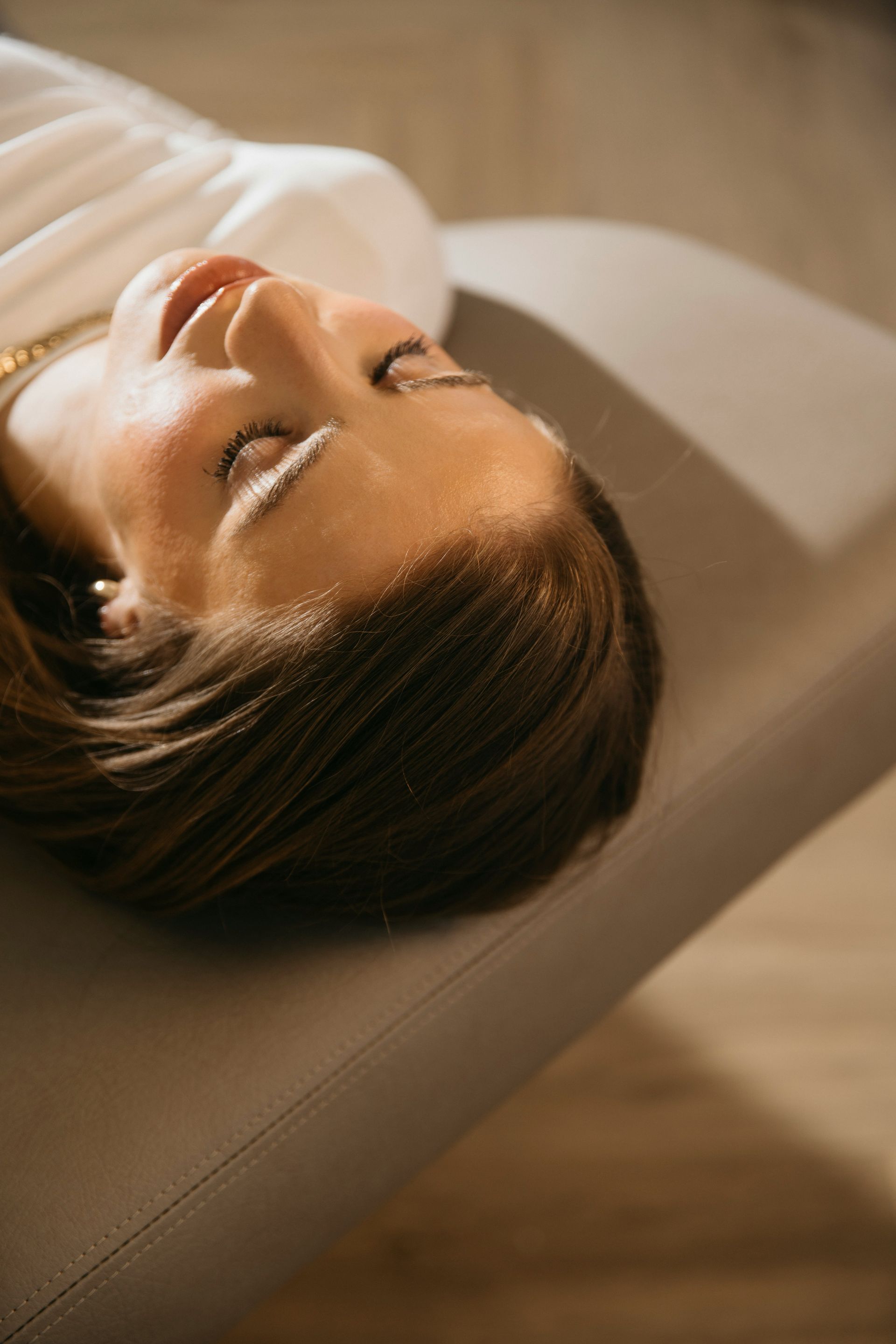 a woman laying on a couch with her eyes closed
