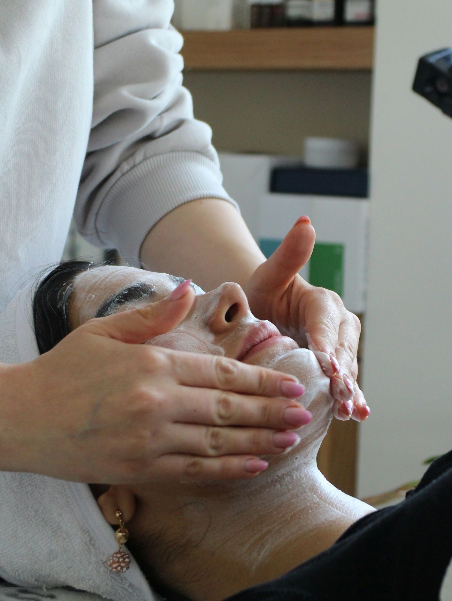 A woman getting a facial mask on her face